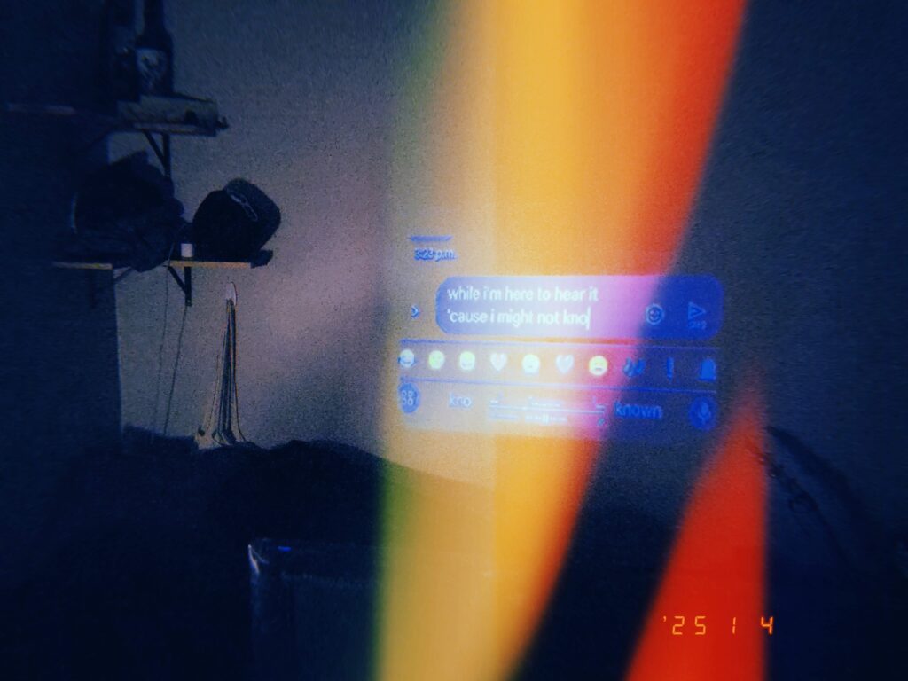 a disposable camera style picture of a projection of text messages against a wall over a bed